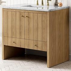 a bathroom vanity with two faucets and a marble counter top in the corner