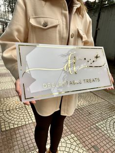 a woman holding up a sign that says delibes table treats