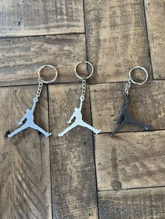 two air jordan keychains sitting on top of a wooden floor