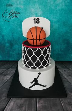 a three tiered cake with a basketball and net on top