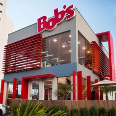 the exterior of a store with red and white stripes on it's facade, including an awning