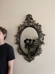 a man standing next to a wall with a mirror on it