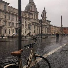 a bicycle parked on the side of a wet street