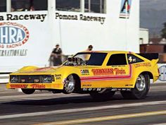 a yellow car driving down a race track