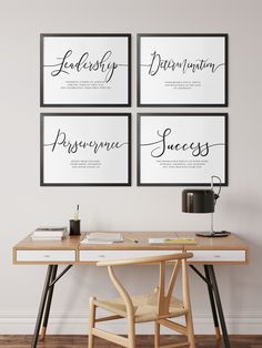 four black and white prints on the wall above a desk with a coffee cup, pen and