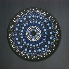 a black and blue plate with white dots on it's center, in the shape of a circle