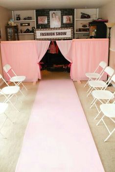 a pink carpeted room with white chairs and a sign that says fashion show on it