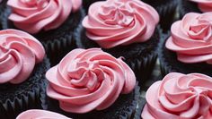 many cupcakes with pink frosting on them are arranged in a row and ready to be eaten