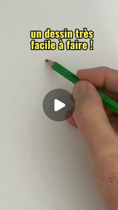 a person is writing on a piece of paper with a green pen in their hand