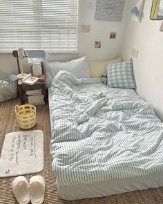 a bed sitting in a bedroom next to a window covered in blue and white sheets