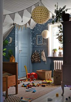 a child's room with blue walls and toys on the floor in front of it