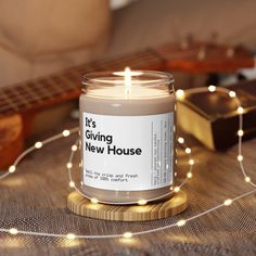 a candle sitting on top of a table next to a string of lights and a guitar