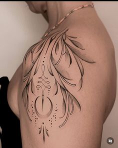 the back of a woman's shoulder with an intricate tattoo design on her arm