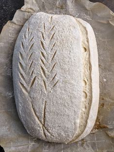 a piece of bread that is sitting on top of wax paper and some type of dough