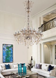 a living room filled with furniture and a chandelier hanging from the ceiling above