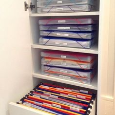 an organized closet with files and folders in the bottom shelf, including file folders