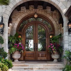 the entrance to a home with potted plants and flowers on either side of the door