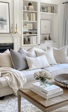 a living room filled with white furniture and lots of pillows on top of it's couch