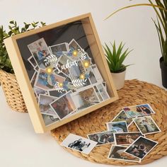 there is a basket with pictures on it next to a potted plant and some plants