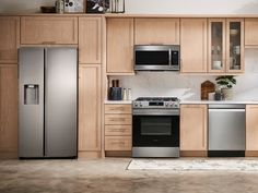 a modern kitchen with stainless steel appliances and wood cabinetry, along with an area rug on the floor