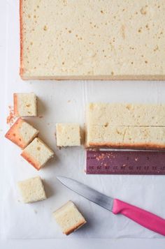 the food is being cut into squares and placed on top of paper next to a knife