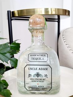 a bottle of gin sitting on top of a table next to a potted plant