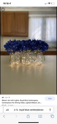 three vases filled with blue flowers on top of a table