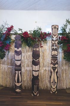 three totems are standing next to each other in front of flowers and grass