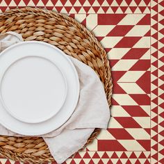 a white plate sitting on top of a woven basket next to a napkin and fork