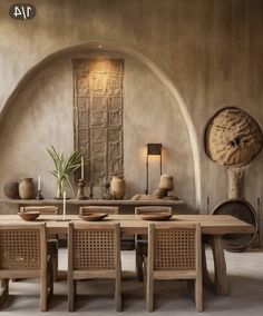 a large wooden table surrounded by chairs in a room with stone walls and arched doorways