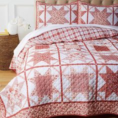 a red and white quilted bedspread on top of a bed in a room