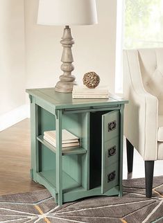 a green table with two drawers and a lamp on top