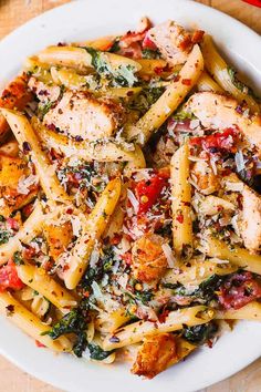 a white plate topped with pasta and chicken