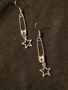 Safety pins on earring hooks, accented with open (hollow) star charms, set of 2 earrings, each measures about 2.5 inches.  Silver tone.  Handmade, unisex jewelry.  Ready to ship. To continue shopping: http://www.rrrobinnn.etsy.com Early 2000 Jewelry, Outfits With Safety Pins, What To Make With Safety Pins, Home Made Earing, Tom Boy Jewelry, Cool Earings Ideas, Bottle Tab Earrings, Tomboy Jewelry Accessories, Grunge Jewelry Diy