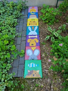 the sidewalk is made out of colorful blocks with animals painted on them and plants around it