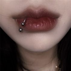 a woman's lips with piercings on them