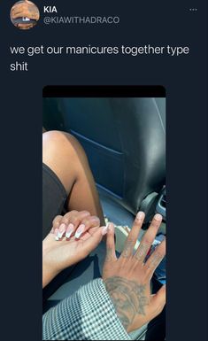 two hands with white and black nail polish on them, one is holding the other's hand