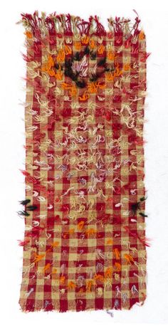 an old piece of cloth with fringes and flowers on the edges is shown in color