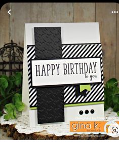 a happy birthday card with black and white stripes on the front, green leaves in the background