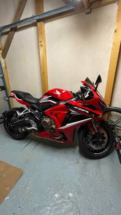 a red and black motorcycle parked in a garage