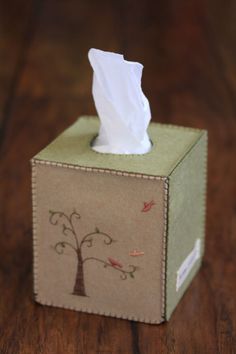 a tissue dispenser sitting on top of a wooden table