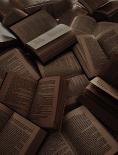 many open books laying on top of each other in the middle of a floor full of them