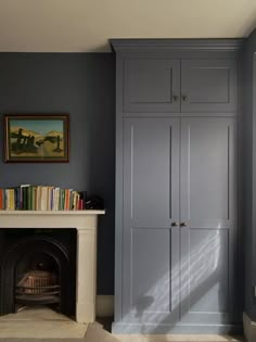 a living room with a fireplace and bookshelf next to a painting on the wall