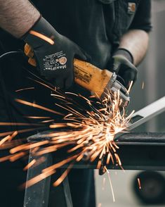 welder cutting metal with an electric grinder on the table in front of him