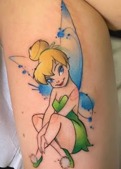 a woman with a tattoo on her thigh that has a tinkerbell sitting on it