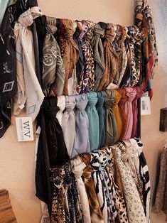 there are many scarves hanging on the wall