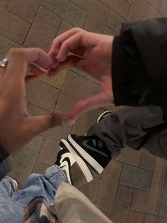 two people sitting on the ground holding hands and touching each other's fingers with their fingers