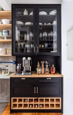 a kitchen with black cabinets and glass doors on the front, white walls and floor