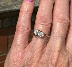 a woman's hand with two diamond rings on it