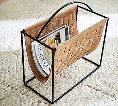 a magazine rack with magazines in it on a carpeted floor, holding magazines and magazines